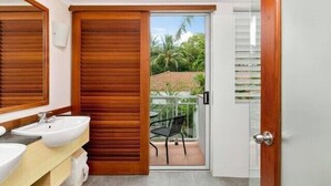 Une salle de bain avec une porte en bois, un lavabo et un miroir.