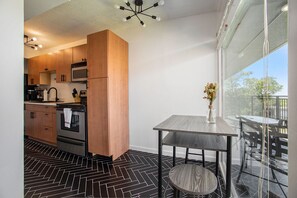 Eine moderne Küche mit Holzausstattung, einem eingebauten Ofen und einem Essbereich mit Tisch und Stühlen.