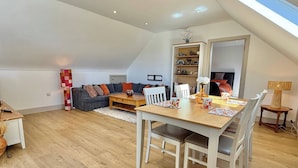 Un espacio habitable tipo loft con comedor, sofá y estantería.