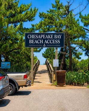 A wooden bridge leading to Chesapeake Bay Beach Access with a truck parked nearby. - 2BR Beach Bungalow | Walk to Beach | Sleeps 5 (Norfolk)