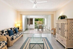 Ein Wohnzimmer mit einer Couch, einem Glastisch und einem Schrank.