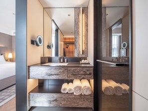 A modern bathroom with a large mirror, a sink, and two towel racks with towels. - IntercityHotel Dongguan Dongcheng Wanda (Dongguan)