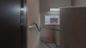 A modern elevator with a metallic handrail and a door with a textured surface. - 5963 Hotel Higashi Ikebukuro (Tokyo)