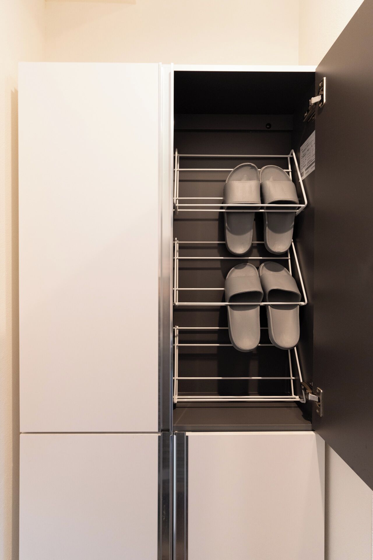 A built-in shoe rack with multiple shelves holding shoes.