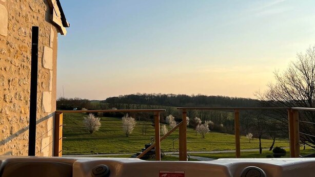 A hot tub with a view of a stone building and a green landscape. - La Grange - Pleasure in Nature & Calm (FLERE LA RIVIERE)