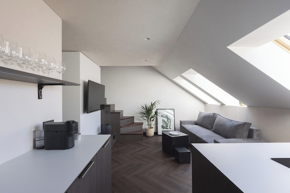 Un loft moderno con cocina, comedor y sala de estar con tragaluz.