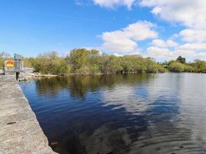 A calm river with a concrete embankment and a metal railing. - CAHIR COTTAGE, family friendly in Ballinrobe, County Mayo (Ballinrobe)