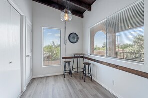 A room with a wooden ceiling, a round table with stools, a wall clock, and large windows with blinds. - Spacious 2Bed 2bath condo w/pool and spa! (Tucson)