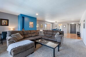 A living room with a sectional sofa, a glass coffee table, and artwork on the walls. - Spacious 2Bed 2bath condo w/pool and spa! (Tucson)