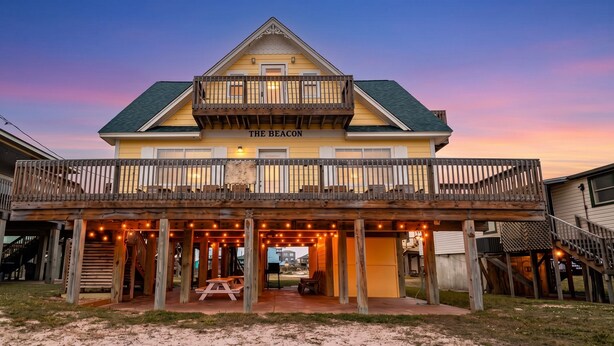 A two-story building named 'The Beacon' with a balcony, outdoor seating, and a covered patio area. - Ocean View l Big 5BR Home l Easy Beach Access (Surfside Beach)