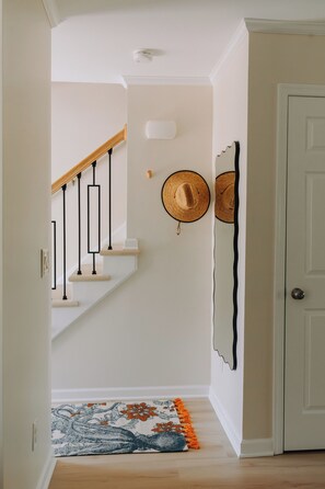 A staircase with a wooden handrail, a white door, and a patterned rug. - Sunny  3-bedroom townhome with Pool in charming Lewes (Lewes)