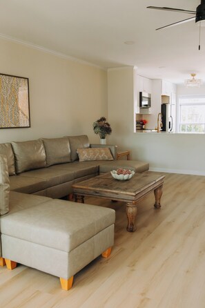 A living room with a sectional sofa, a coffee table, and a dining area. - Sunny  3-bedroom townhome with Pool in charming Lewes (Lewes)