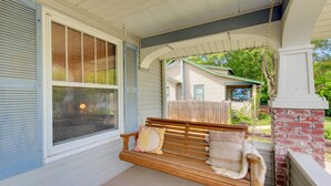 A porch with a wooden bench, a window, and a brick wall. - Charming Bungalow 4bd/2ba, Huge Deck and Sunroom (Manhattan)