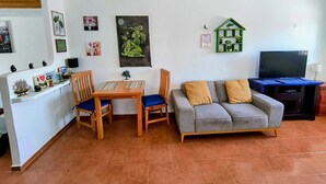 A living room with a sofa, a TV, a small table, and chairs. - Capitan Tiega House (Isla Mujeres)