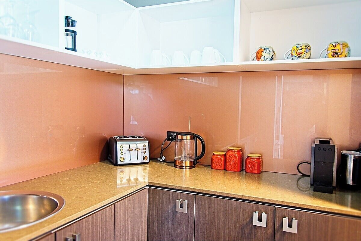 A kitchen with a toaster, coffee maker, and jars on the counter.