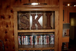 Ein Holzregal mit beleuchteten Buchstaben 'SKI' und einer Reihe von DVDs darunter.