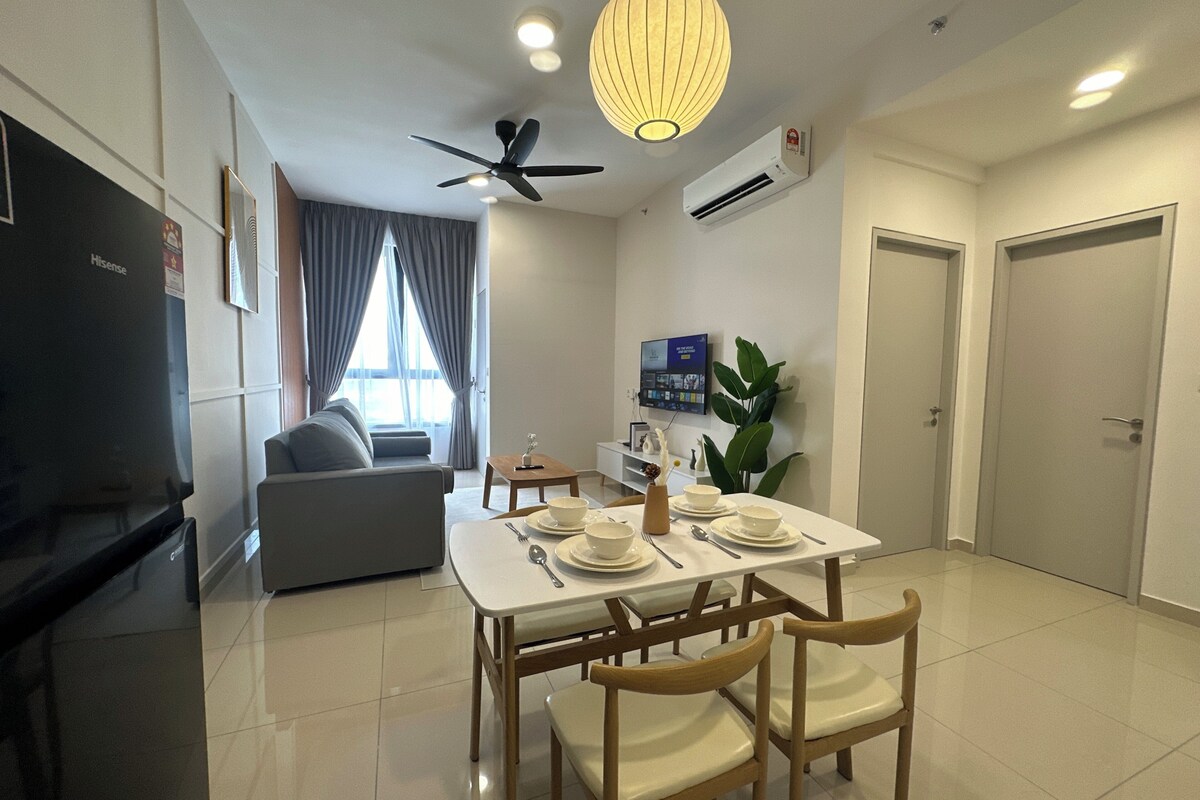 A modern living room with a sofa, a dining table set for two, a ceiling fan, and a large window with curtains.
