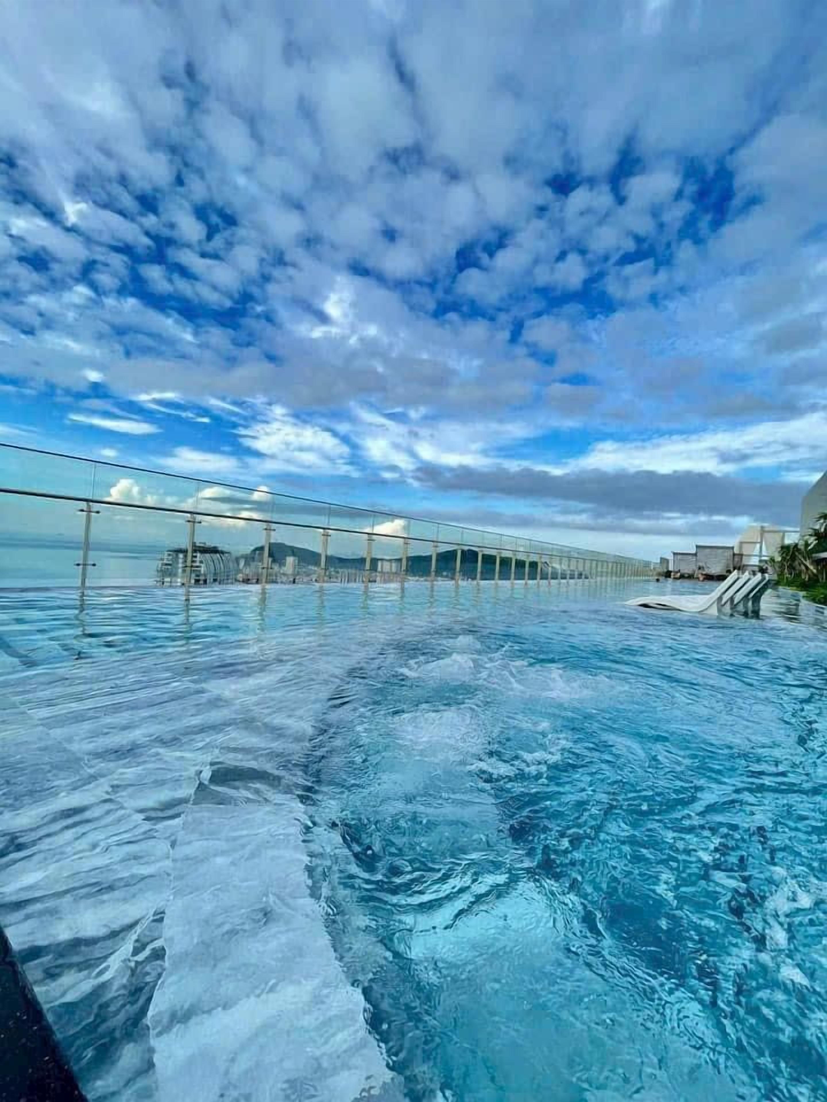 Una piscina a sfioro con vista sull'oceano e un ponte.