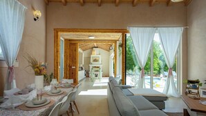 Una habitación amplia con comedor, sofá y vistas al exterior.
