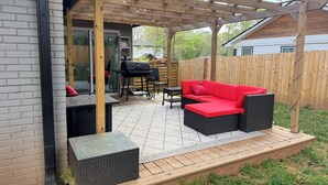 A covered patio with a grill, outdoor furniture, and a wooden pergola. - 3BR House 5 Minutes from Downtown Atlanta near Mercedes Benz Stadium World Cup (Decatur)