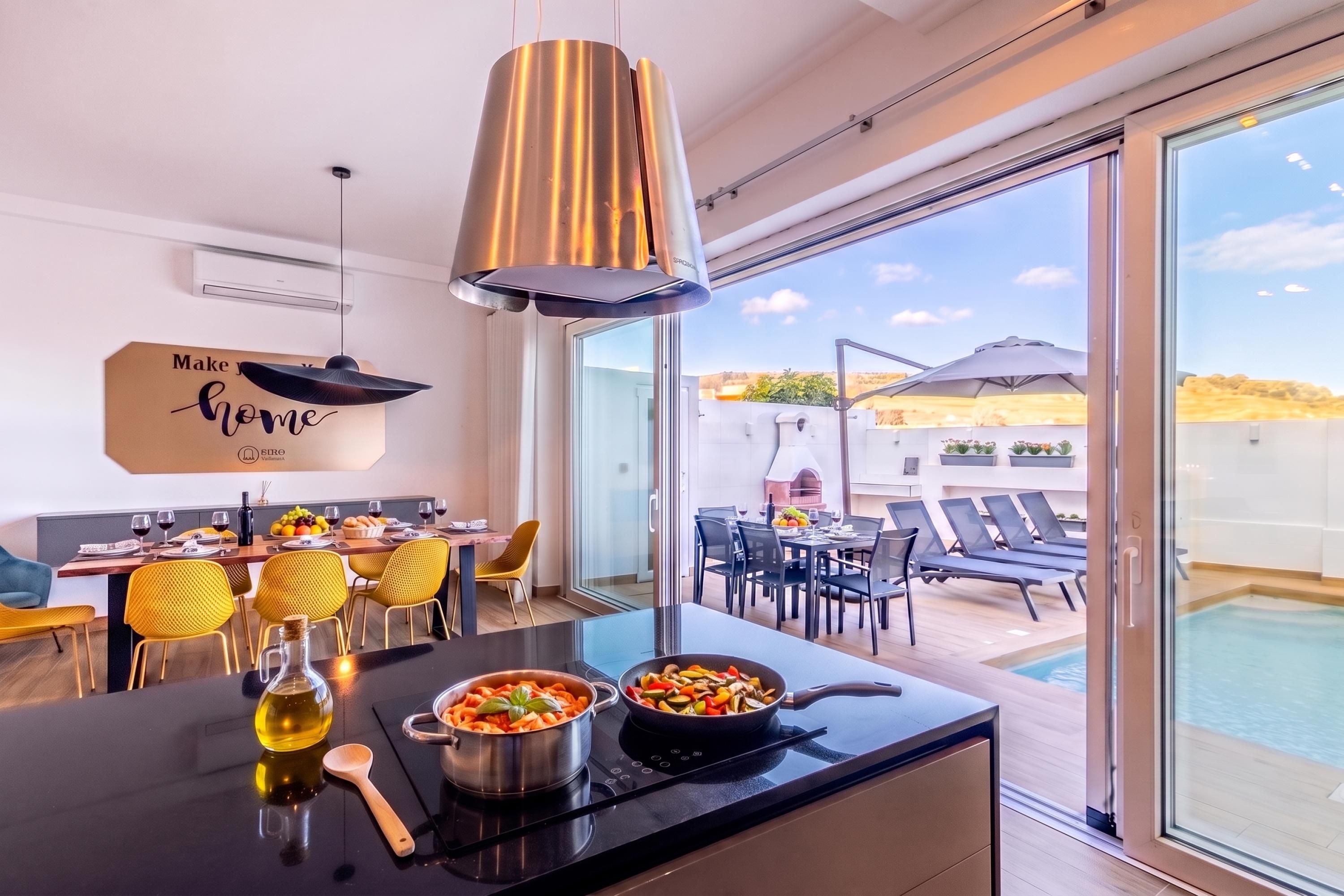 A modern kitchen with a dining area, a view of the outdoor pool, and a sign that reads 'Make your home.'