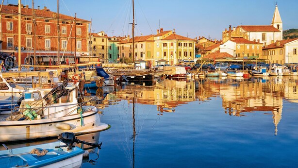 A marina with boats docked, buildings with red and yellow facades, and a church with a bell tower. - Rural Apt Lea for 2 /w Terrace, Šmarje, Slovenia (Šmarje)