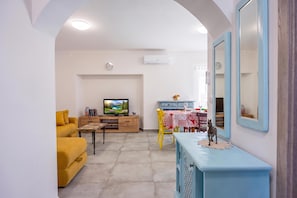 A living room with a sofa, a TV, a dining table with chairs, and a blue cabinet. - Rural Apt Arya: Garden & BBQ, Šmarje, Slovenia (Šmarje)
