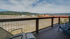Eine Terrasse mit Stühlen und Blick auf eine Wüstenlandschaft, im Hintergrund sind Gebäude zu sehen.