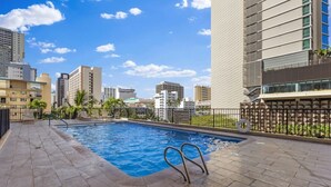 A rooftop swimming pool with a view of surrounding buildings. - Waikiki Hideaway · Canal Views•Pool•Parking•W/D (Honolulu)