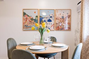 A dining table set with plates, glasses, and a vase with flowers.