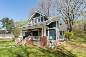 A two-story house with a porch, a staircase, and a fenced yard.