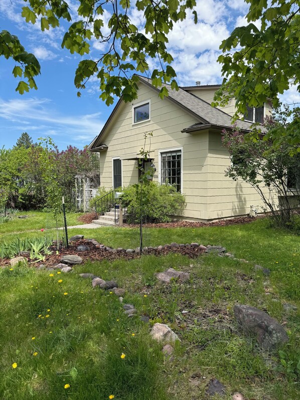 A two-story house with a front yard, a small tree, and a mailbox.