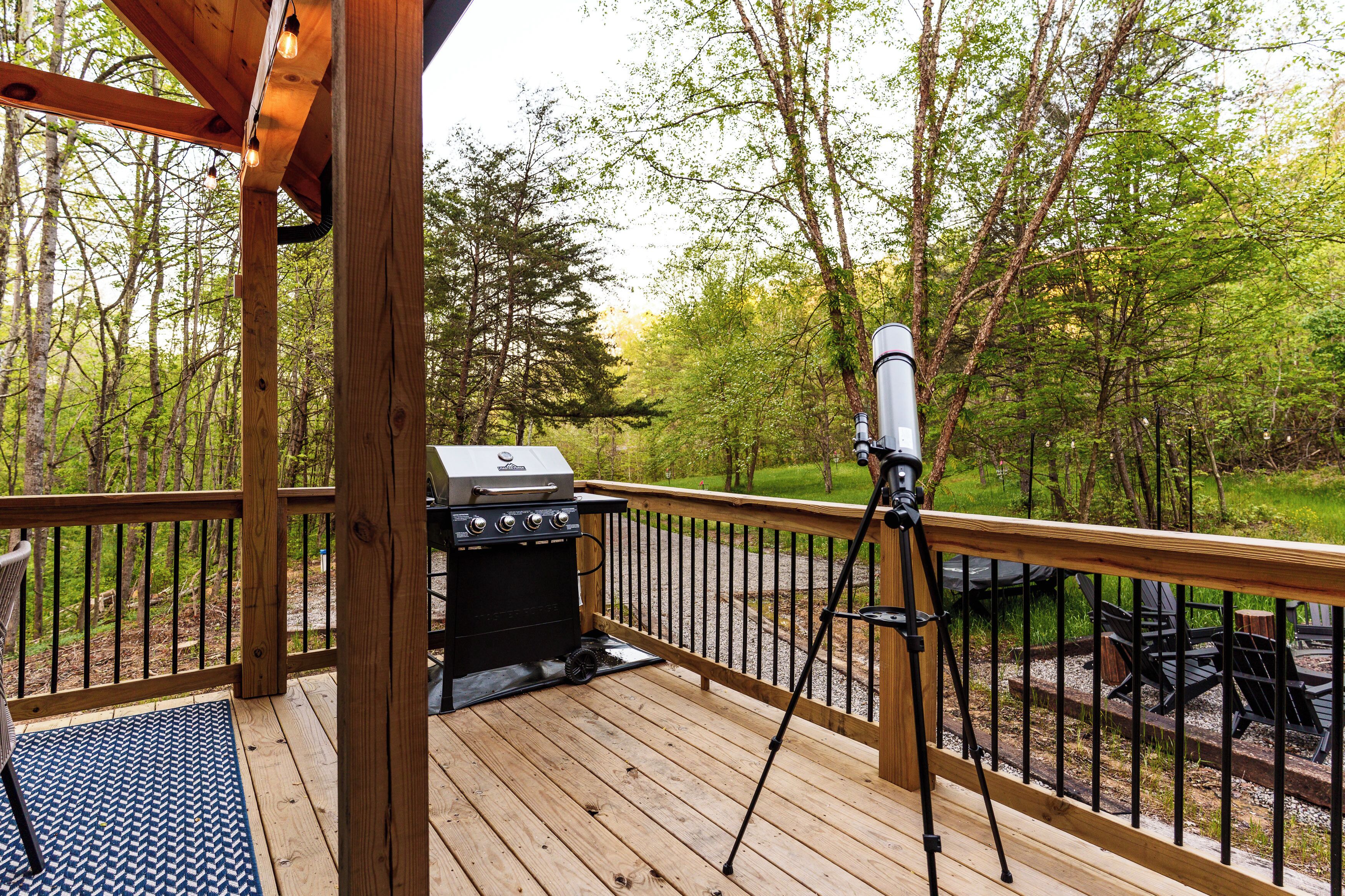A wooden deck with a grill and a telescope.