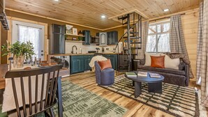 Een knus interieur in chaletstijl met een eethoek, keuken en zithoek.