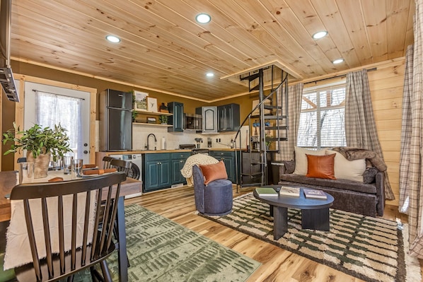 A cozy cabin-style interior with a dining area, kitchen, and living space.