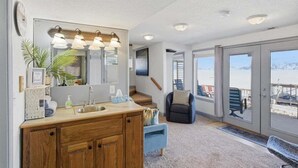 Une salle de bain avec un meuble-lavabo en bois, un grand miroir et un lavabo.