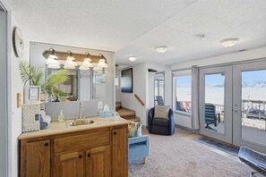 Ein Badezimmer mit einem Holzbadschrank, einem großen Spiegel und einem Waschbecken.