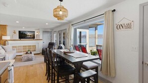 Un salon moderne comprenant un coin repas, une cheminée et une vue sur le lac.