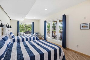 Ein Hotelzimmer mit zwei Betten, einem Balkon und Blick auf Grünflächen.