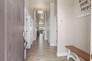 Ein Hotelgang mit Holzboden, weißen Wänden und Zimmertüren auf beiden Seiten.