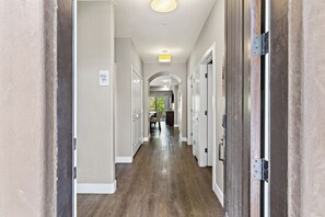 A hallway with white doors, a wooden floor, and a ceiling light. - Estancia Resort Unit #106 (Saint George)