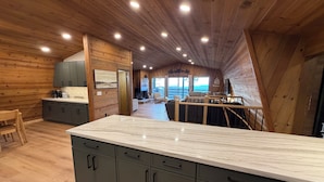 Een moderne keuken met houten wanden, een marmeren aanrechtblad en uitzicht op de omgeving.