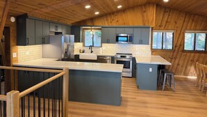 Een moderne keuken met houten plafond, roestvrijstalen apparatuur en een groot kookeiland.