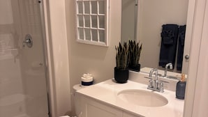 A bathroom with a shower, toilet, sink, and mirror. - Your Indio retreat awaits you (Indio)