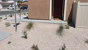 A residential building with a stop sign, a red door, and a gravel driveway. - Your Indio retreat awaits you (Indio)