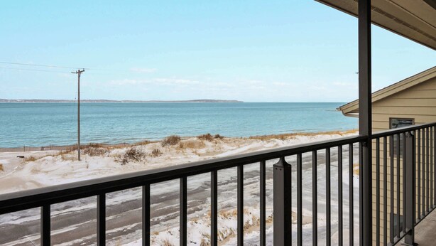 Ein Balkon mit Blick auf einen Strand und das Meer.