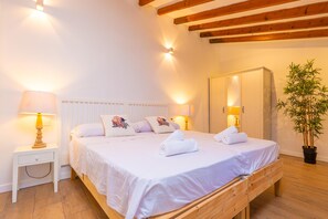 A bedroom with a wooden bed, bedside lamps, a potted plant, and a wardrobe. - BONITO MEDITERRANEO - Charming village house with private pool and free Wi-Fi (Santanyí)