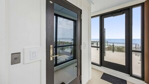 Habitació d'hotel amb una gran porta corredissa de vidre que dona a un balcó amb vista a la platja.