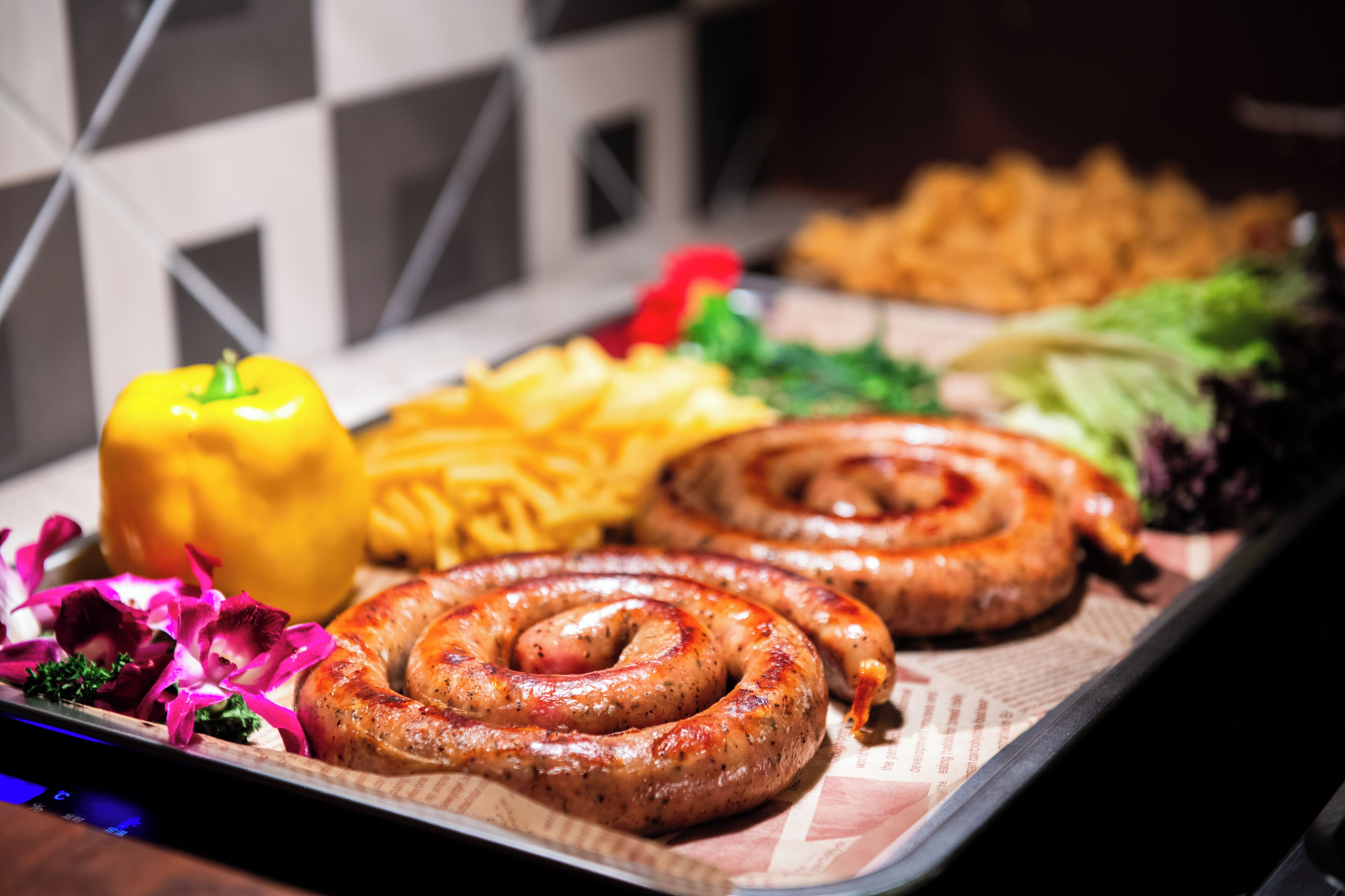 A tray with sausages, fries, and vegetables.