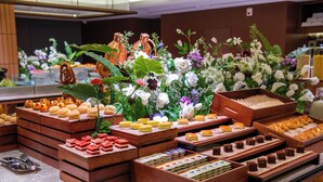 A buffet with various food items and a floral arrangement. - IntercityHotel Guangzhou Huadu (Guangzhou)